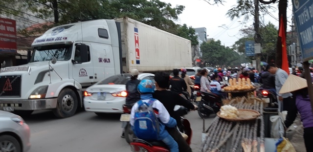 Những người kịp đến đón con thì gặp nhiều khó khăn trong việc tìm chỗ đứng, di chuyển phương tiện để tránh va chạm với xe container.