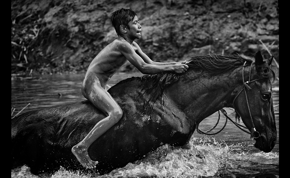 Giải nhất chủ đề Thể thao (hạng mục ảnh bộ) Nhiếp ảnh gia Bỉ Alain Schroeder, người sáng lập hãng báo ảnh Bỉ, đã được trao tặng cho tác phẩm “Kid Jockeys”. Nội dung ảnh miêu tả những đứa trẻ cạnh tranh trong cuộc đua ngựa Maen Jaran, trên đảo Sumbawa ở Indonesia. (Ảnh: Alain Schroeder / Phóng viên)