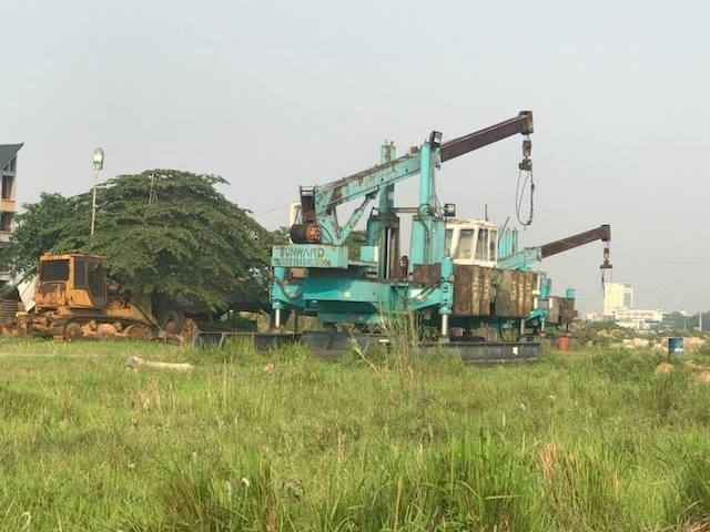 Máy xúc, máy san nền và các thiết bị xây dựng để lâu hoen gỉ, cây cỏ mọc che lấp