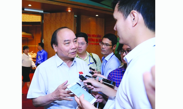 Thủ tướng Chính phủ Nguyễn Xuân Phúc trao đổi với báo chí bên hành lang Quốc hội