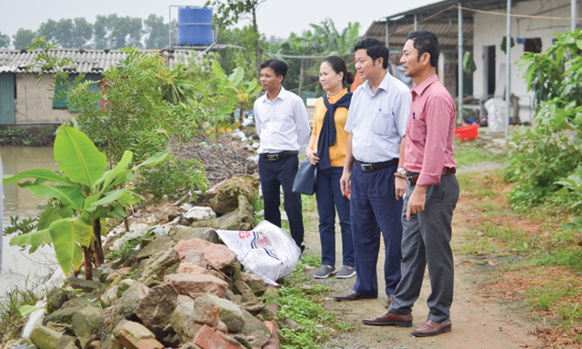 Ông Phạm Văn Cảnh - Chủ tịch HĐQT kiêm Giám đốc HTX Hợp Lực (áo đỏ), hướng dẫn khách tham quan ao cá của HTX