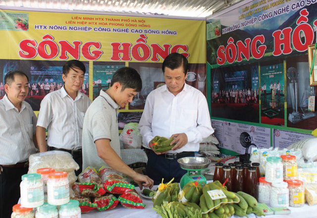 Chủ tịch Liên minh HTX Tp.Hà Nội Lê Văn Thư tham quan một gian hàng của HTX