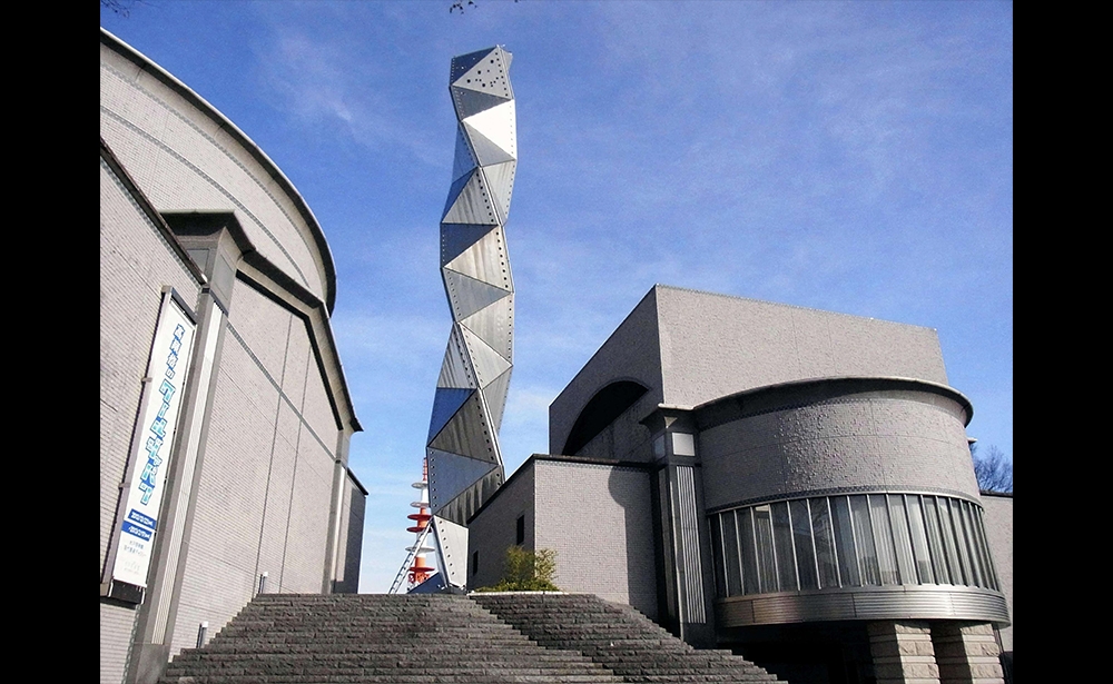 2019 : Arata Isozaki Kiến trúc sư người Nhật, Arata Isozaki, được vinh danh ở Pritzker 2019, đã thiết kế các công trình theo những biến đổi không ngừng ở cả bốn châu lục. « Tôi không thể chỉ theo đuổi mãi một phong cách. Phải liên tục thay đổi. Điều đó đã trở thành phong cách cá nhân của tôi», kiến trúc sư Arata Isozaki lý giải. Các kiến trúc của ông gồm : Bảo tàng Nghệ thuật đương đại Los Angeles (1986)- tác phẩm xuất ngoại đầu tiên; Đấu trường thể thao Palau Sant Jordi được thiết kế cho Thế vận hội Olympic ở Barcelona (1990) ; Trung tâm Học viện nghệ thuật của Bảo tàng nghệ thuật Bắc Kinh (2008). Trong ảnh : Tháp nghệ thuật Mito tại Nhật, khánh thành năm 1990 (ảnh Sipa)