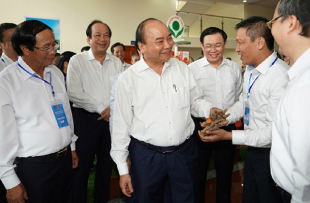 Thủ tướng tham quan các gian hàng của doanh nghiệp tại Hội nghị ngày 25/6. Ảnh: VGP.