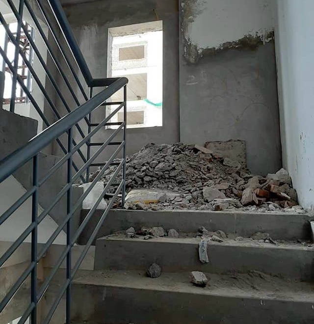 Cầu thang thoát hiểm đầy gạch và vữa tường chắn hết lối đi