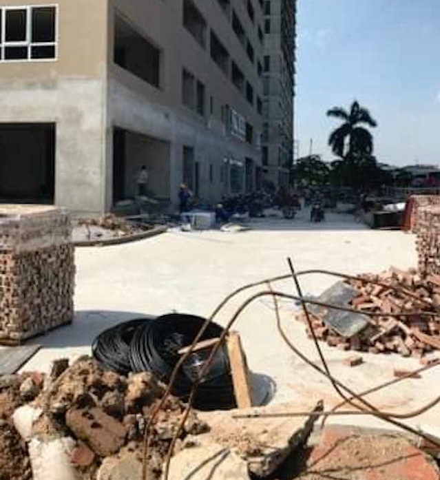 Phía ngoài toà nhà gạch, đá, sắt thép vẫn còn đang xếp đống để thi công