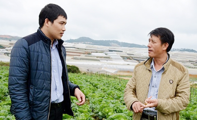 Anh Khẩn (phải) trao đổi kinh nghiệm trồng rau công nghệ cao