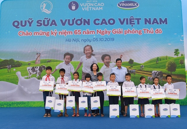 Bà Trương Thị Mai - Ủy viên Bộ Chính trị, Bí thư Trung ương Đảng, Trưởng ban Dân vận Trung ương cùng đại biểu khách mời trao học bổng và sữa của Quỹ sữa Vươn cao Việt Nam cho các em học sinh khó khăn có thành tích học tập tốt của trường Tiểu học Tiên Dược B, Hà Nội