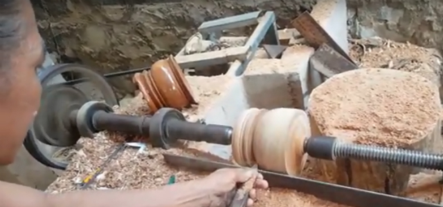 Một người thợ đã qua đào tạo đang thao tác tiện lộc bình.