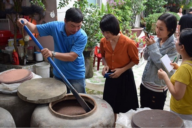 Người dân làng nghề nước mắm Nam Ô giới thiệu về phương pháp làm mắm theo công thức gia truyền “ 3 cá 1 muối” (Ảnh: Tư liệu)
