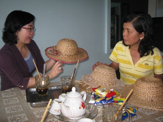 Bà Phạm Thị Tơ (mặc áo kẻ vàng sọc ngang) giới thiệu về sản phẩm đan lục bình