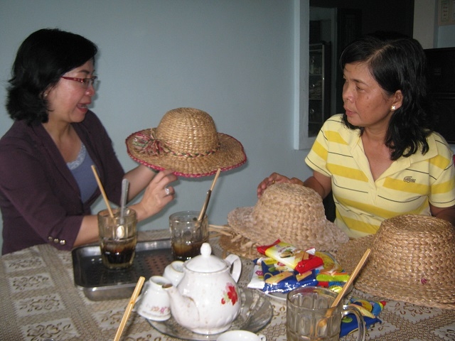 Bà Phạm Thị Tơ (mặc áo kẻ vàng sọc ngang) giới thiệu về sản phẩm đan lục bình