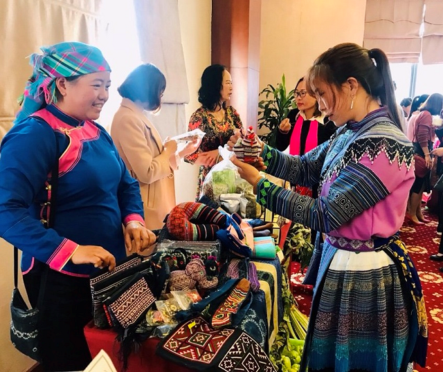 Chị Sùng Thị Lan (bên trái) giới thiệu sản phẩm tới khách hàng (Ảnh: TL)