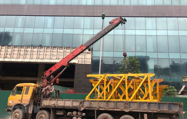 Từ chiều 22/4, phương tiện được tập kết tại chân tòa nhà 8B Lê Trực chuẩn bị cho việc tháo dỡ, cắt ngọn tầng 17,18 sai phép của tòa nhà (Ảnh TTXVN)