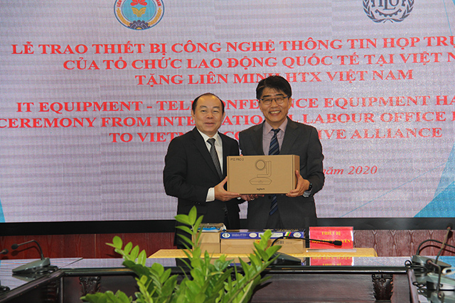 Ông Chang Hee Lee, Giám đốc ILO tại Việt Nam (bên phải) trao tặng thiết bị công nghệ thông tin họp trực tuyến cho Chủ tịch Liên minh HTX Việt Nam Nguyễn Ngọc Bảo (Ảnh: Phạm Duy)