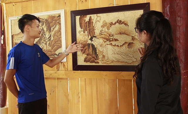 Giám đốc Phạm Thanh Lâm giới thiệu sản phẩm tranh gạo cho khách hàng (Ảnh:TL)