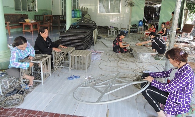 Các thành viên THT đan dây nhựa đang làm việc tại nhà chị Nguyễn Thị Bích Lệ (Ảnh: TL)