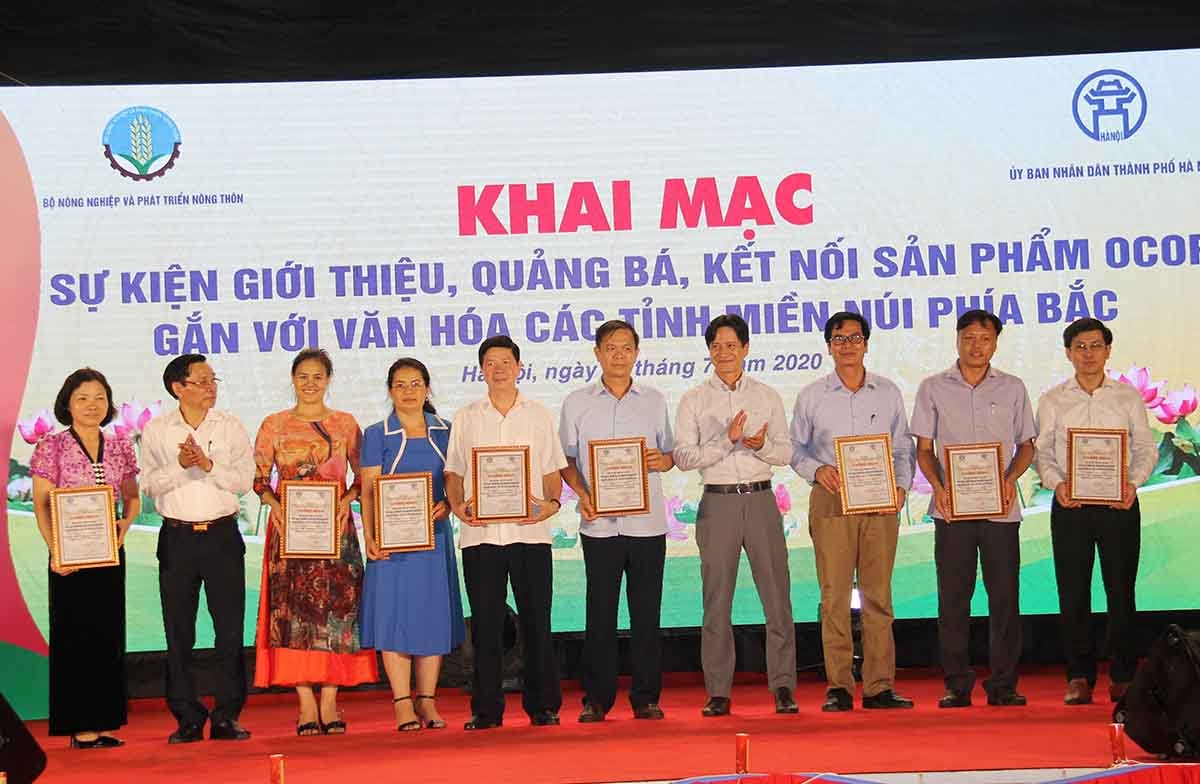 Đại diện Văn phòng Điều phối Nông thôn mới Trung ương và Sở Nông nghiệp và Phát triển nông thôn Hà Nội trao giấy chứng nhận cho các địa phương tham gia hội chợ (Ảnh: Phạm Duy)