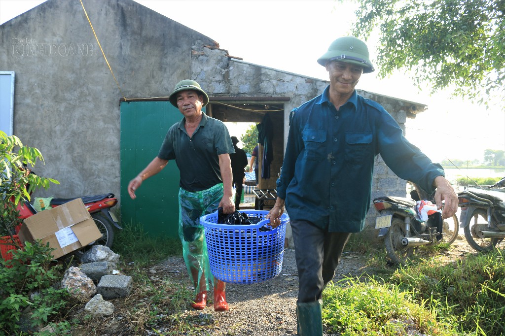 Hàng chục giỏ cá nặng trĩu tay được vận chuyển ra xe.