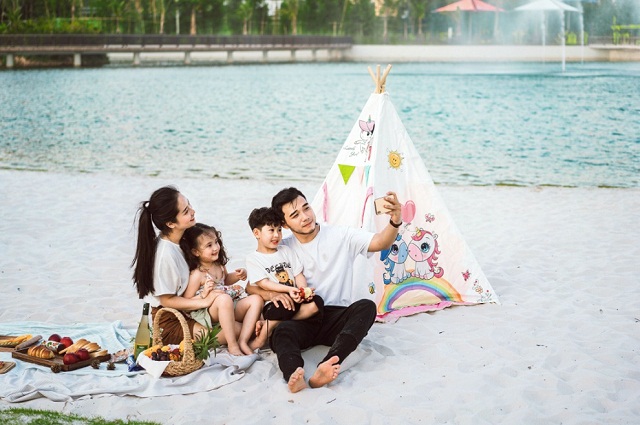 Công viên trung tâm với điểm nhấn hồ nước trải cát trắng trong mát và hệ thống cây xanh phủ khắp công viên.