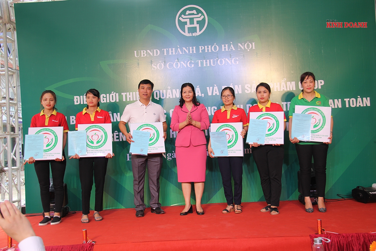 Bà Trần Thị Phương Lan (đứng giữa) trao giấy chứng nhận và biển công nhận cửa hàng bán sản phẩm OCOP cho các đơn vị.