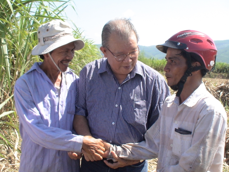 GS. Võ Tòng Xuân siết tay anh Nguyễn Tình (trái) và Tô Văn Tùng (phải), 2 trong số 43 nông dân trồng mía ở thôn An Lợi, Phổ Nhơn, Đức Phổ, tỉnh Quảng Ngãi, sung sướng với kết quả năng suất mía cao hơn mà giá thành thấp hơn nhờ dồn điển đổi thửa.