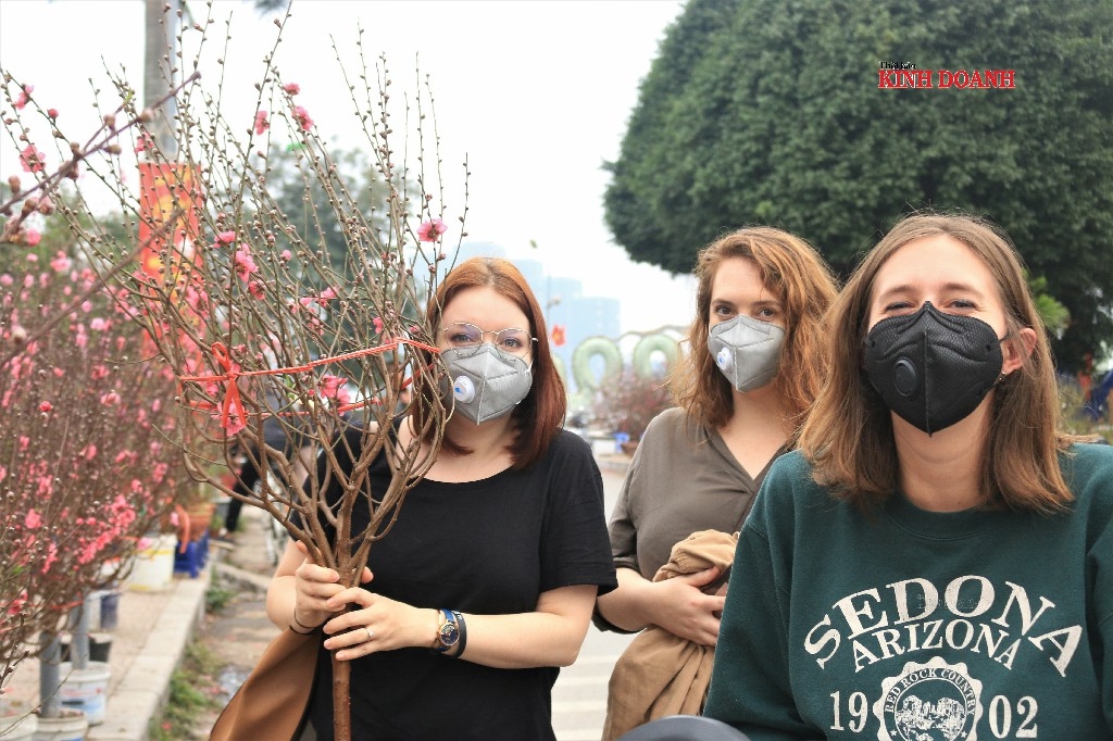 Những vị khách nước ngoài cũng vui vẻ xuống phố tậu một cành đào về đón Tết tại Việt Nam. Một vị khách chia sẻ năm nay là năm thứ hai cô đón Tết ở Việt Nam. Nếu dịch không bùng phát, cô sẽ cùng bạn bè bay vào Phú Quốc du lịch nhưng hiện tại cô phải hủy vé để đảm bảo an toàn. Tết Nguyên đán khá thú vị, cô được bạn bè người Việt mời đến nhà chơi, được lì xì và kể cho nghe nhiều phong tục như xông nhà, đi chùa... Mọi thứ đều rất tuyệt vời trừ việc ngày Tết các cửa hàng, chợ và siêu thị gần như đóng cửa hết, do đó cô phải tích trữ đồ ăn từ trước Tết.