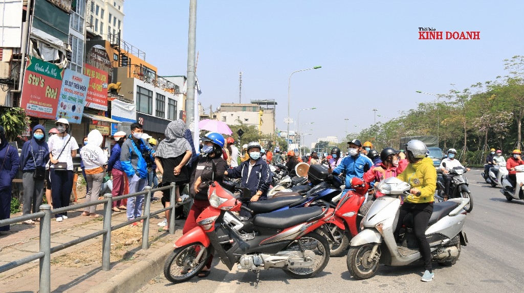 Người dân chờ đợi chuyến xe chở nông sản giữa trời nắng khá gắt.