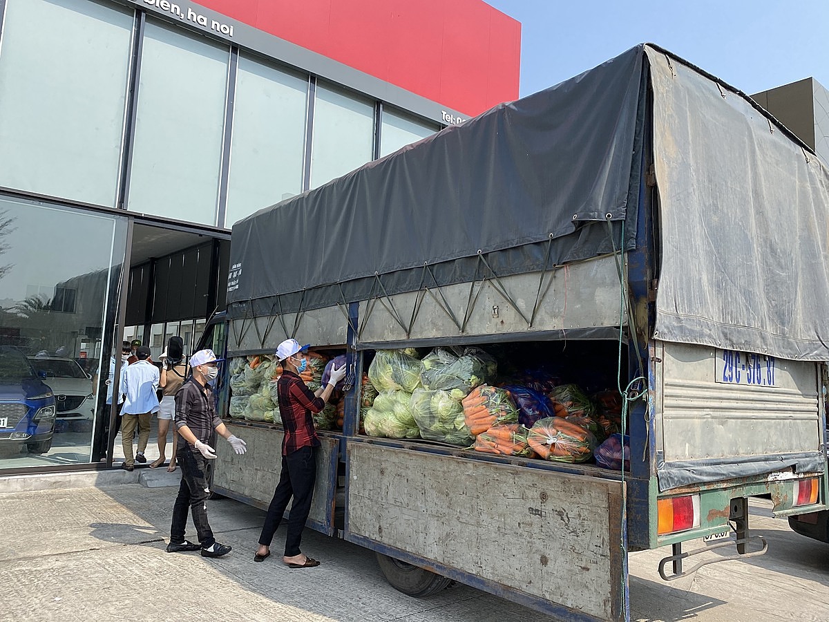 Nhân viên, người dân Hà Nội hỗ trợ bốc hàng giải cứu từ xe xuống.