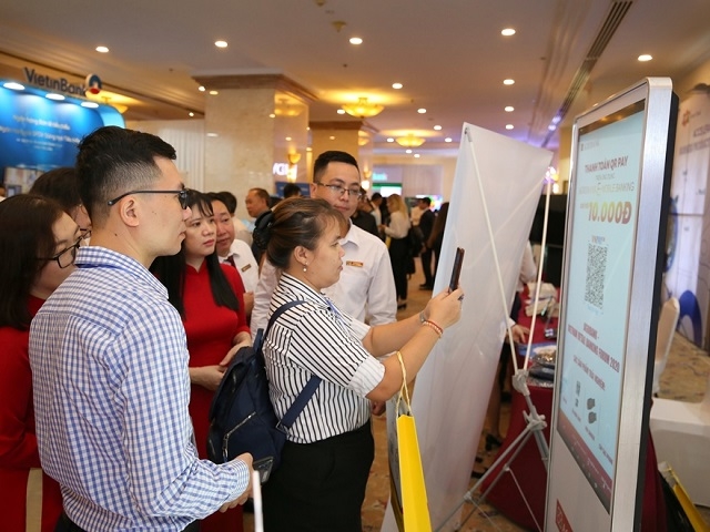 Đại biểu và khách tham quan trải nghiệm các dịch vụ ngân hàng số của Agribank trưng bày tại gian hàng