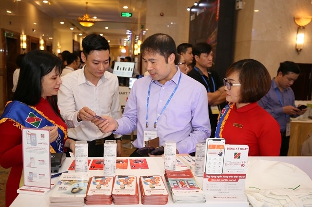 Nhân viên Agribank giới thiệu với đại biểu và khách tham quan trải nghiệm các dịch vụ ngân hàng số của Agribank