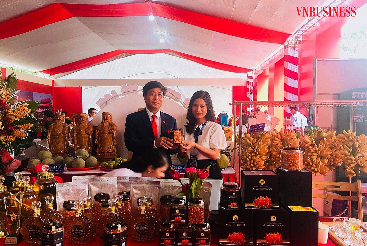 Chị Đỗ Thị Phương, Giám đốc HTX Minh Đức giới thiệu sản phẩm nấm đông trùng hạ thảo với ông Nguyễn Thành Thăng, Chủ tịch UBND huyện Lý Nhân tại hội chợ trưng bày, giới thiệu sản phẩm do UBND tỉnh Hà Nam tổ chức.