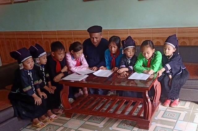 Ông Hoàng Sín Hòa dạy các cháu thiếu niên, nhi đồng học dân ca Nùng Dín (Ảnh:TL)