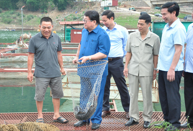 Ông Nguyễn Hữu Sơn (trái) chia sẻ về quy trình nuôi cá đặc sản trên hồ thủy điện Sơn La.