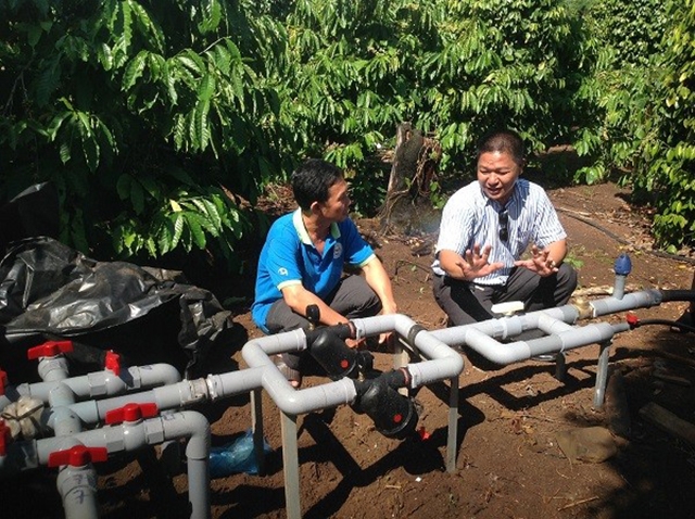 Ông Trương Hoàng Trung (trái), Chủ tịch Hội đồng quản trị HTX Quyết Tiến đang kiểm tra hệ thống đường ống nước tưới của HTX.