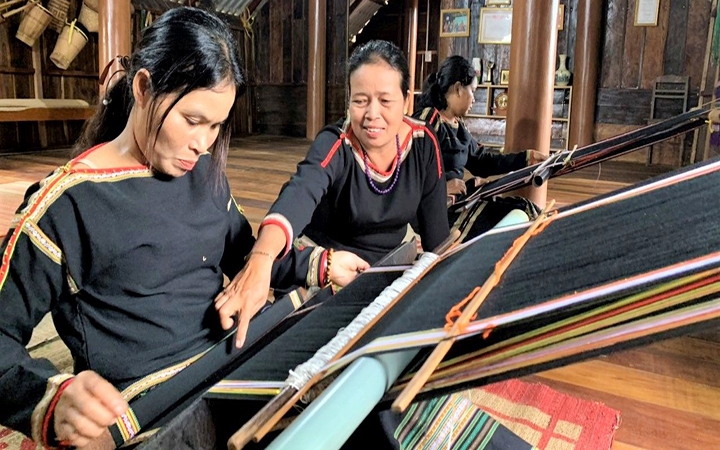 Bà HYam Bkrông, Giám đốc HTX dệt thổ cẩm Tơng Bông (người ngồi giữa) hướng dẫn người lao động dệt thổ cẩm dân tộc Ê Đê.