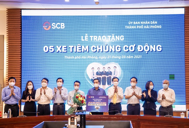 Đại diện SCB trao bảng tượng trưng tặng 05 chiếc xe tiêm chủng cơ động.