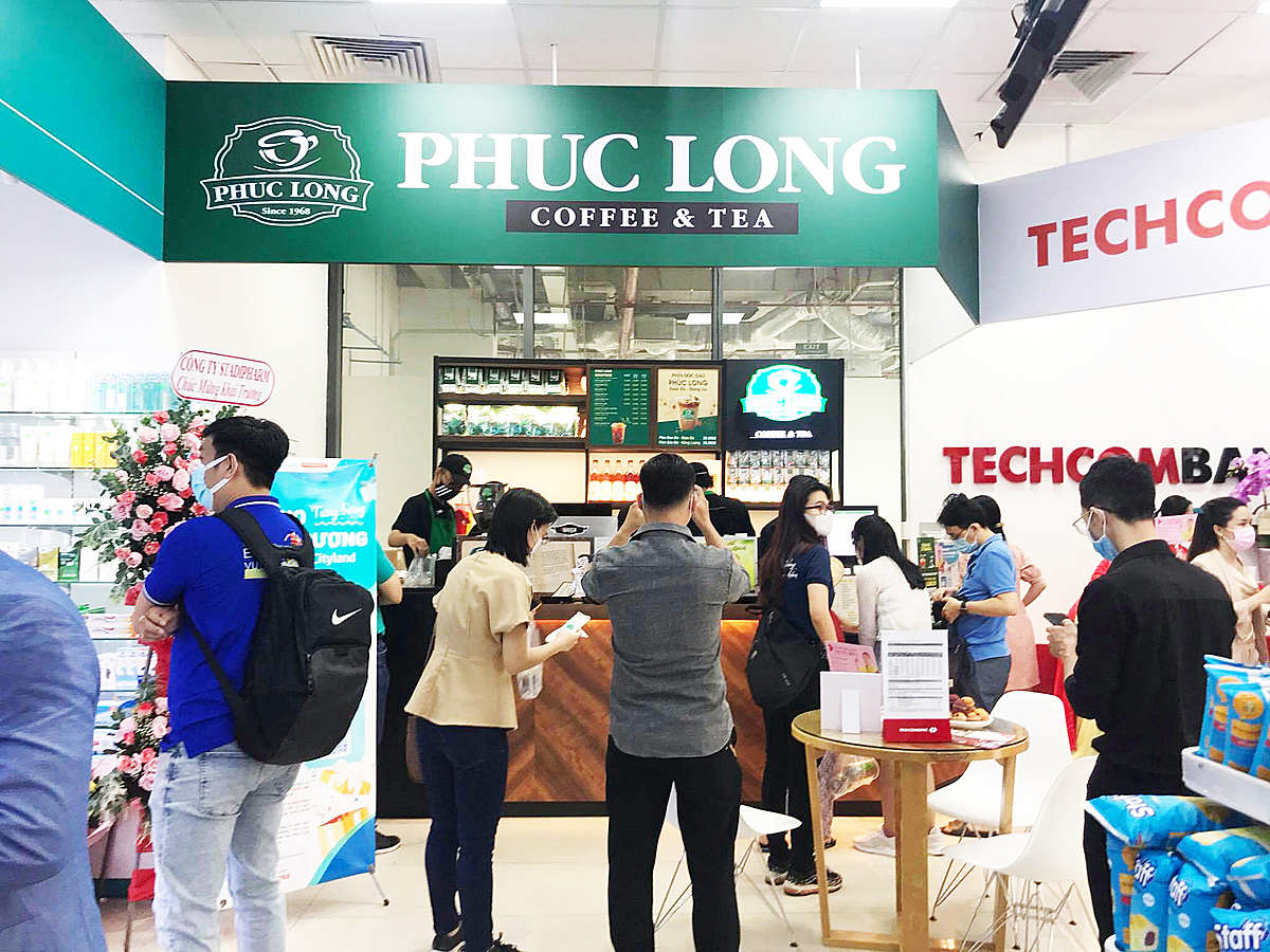 Kiosk Phúc Long đặt ngay cạnh Techcombank với menu đa dạng các loại trà và cà phê để khách hàng thuận tiện mua đồ uống sau khi mua sắm.