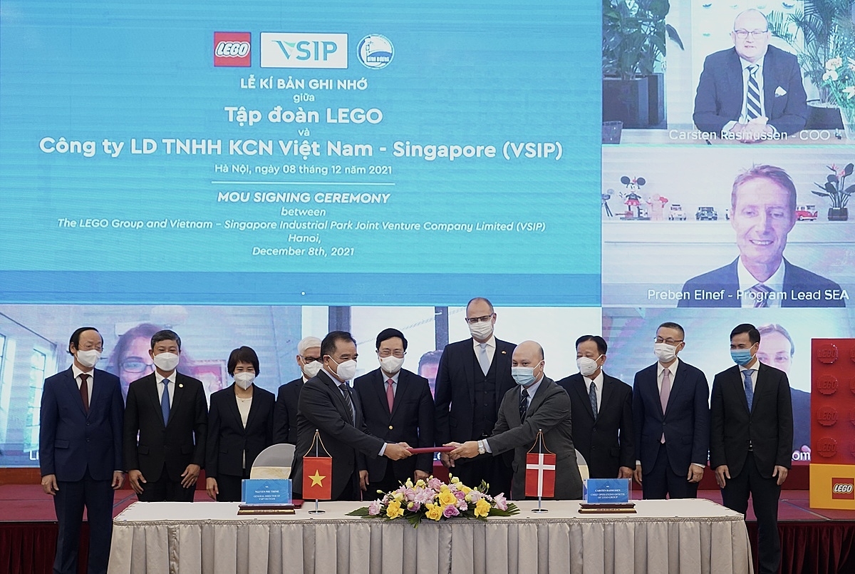 Ông Đỗ Việt Tùng, Giám đốc Đối ngoại Cấp cao, APAC, Tập đoàn LEGO và Ông Nguyễn Văn Hùng, Chủ tịch Tổng Công ty Đầu tư và Phát triển Công Nghiệp Becamex IDC, Đồng chủ tịch VSIP Group (giữa) chính thức hóa quan hệ đối tác giữa hai công ty trong Buổi lễ kí kết Bản ghi nhớ. Buổi lễ có sự tham dự của Phó Thủ tướng thường trực Phạm Bình Minh, Đại sứ Đan Mạch tại Việt Nam, Ông Kim Højlund Christensen (vị trí thứ năm và sáu từ bên trái), Ông Carsten Rasmussen, Giám đốc vận hành, Tập đoàn LEGO (góc trên bên phải) và Ông Preben Elnef, Phó chủ tịch Tập đoàn LEGO phụ trách các hoạt động Đông Nam Á (vị trí giữa bên phải).