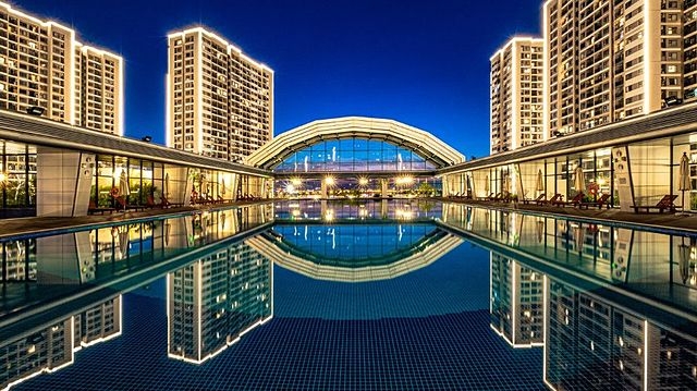 Tổ hợp tiện ích 5 tầng gồm nhà để xe và bể bơi mái kính hiện đại.