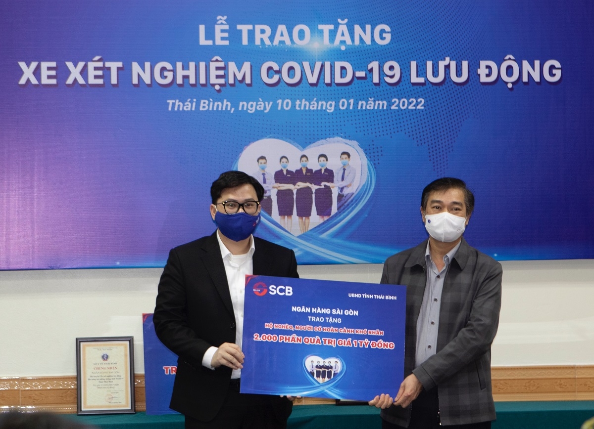 Ông Trương Khánh Hoàng- Q.TGĐ SCB trao bảng tượng trưng tặng 2.000 phần quà trị giá 01 tỷ đồng cho đại diện UBMTTQ Tỉnh Thái Bình- Ông Nguyễn Văn Giang- Trưởng Ban Dân vận tỉnh, Chủ tịch UB MTTQ Tỉnh.