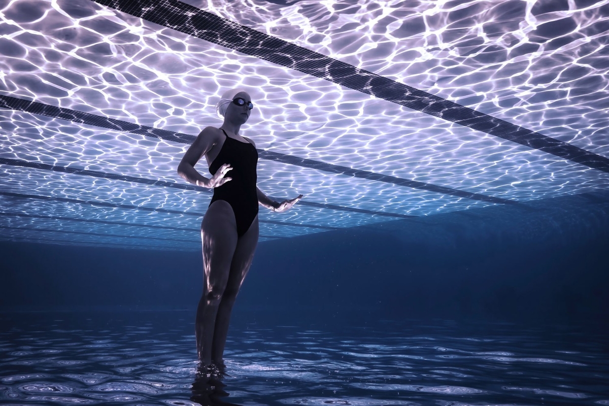 Khoảng trống: Cô con gái Madi của nhiếp ảnh gia rất yêu thích môn bơi. Trong nhiều năm, tác giả đã chụp ảnh cô con gái trong đội bơi nghệ thuật ở Davis, California (Aquastarz). Trong bức ảnh này, Madi đang thực hiện động tác cá nhồng, một trong nhiều động tác bắt buộc phải có trong thi đấu và để thăng tiến trong môn thể thao này. Động tác này yêu cầu Madi xoay người với hai tay để giữ thẳng đứng và sau đó nâng người lên trên mặt nước càng cao càng tốt. Trong ảnh này, góc chụp, ánh sáng và hình dáng thực sự hấp dẫn. © James Rokop / UPY2022