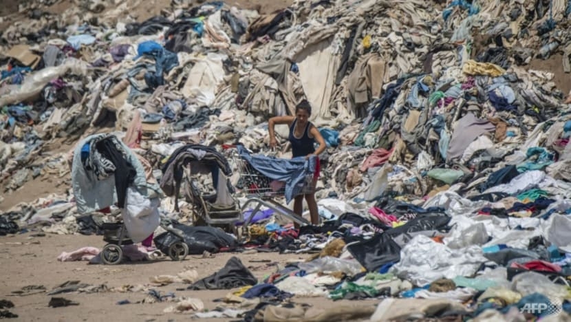 Một người phụ nữ đang tìm kiếm quần áo đã qua sử dụng giữa hàng tấn đồ bỏ đi trên sa mạc Atacama, Alto Hospicio, Iquique, Chile. (Ảnh: AFP)