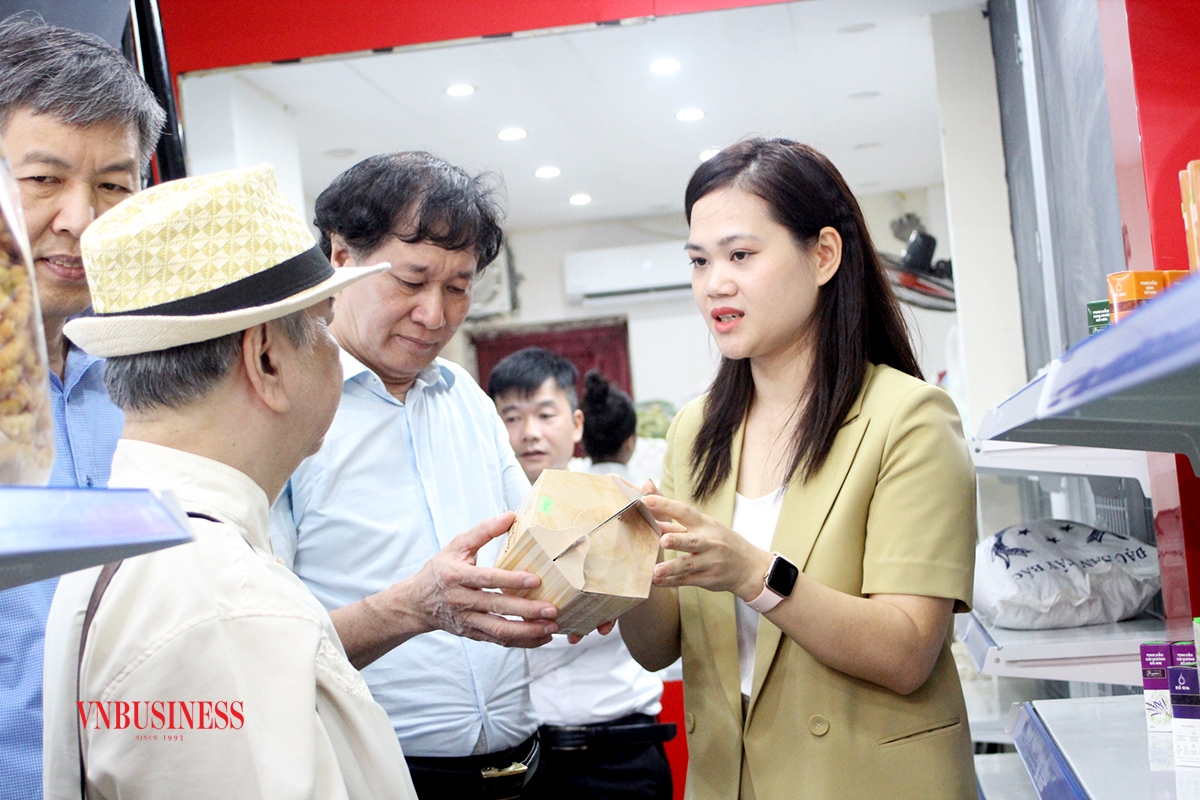 Bà Đỗ Thị Loan Phượng, đại diện doanh nghiệp sáng lập HTX An Khánh, giới thiệu sản phẩm cho đại biểu và khách hàng tham quan cửa hàng.