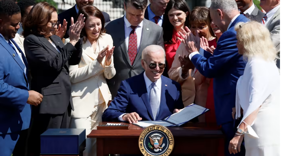 Tổng thống Joe Biden ký Đạo luật Khoa học và CHIPS cùng với Phó Tổng thống Kamala Harris và Bộ trưởng Thương mại Gina Raimondo bên ngoài Nhà Trắng. © Reuters