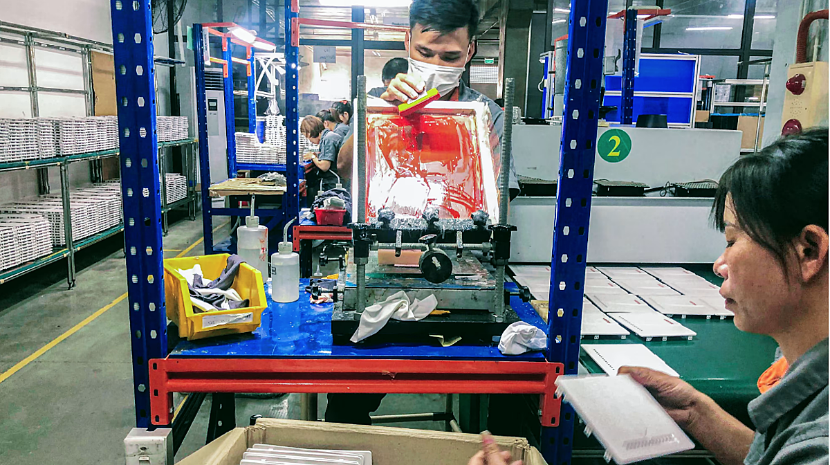 Công nhân nhà máy đang sơn thủ công logo thương hiệu trên các bộ định tuyến internet tại một nhà máy CNCTech, Vĩnh Phúc. Việt Nam là nơi có các nhà máy lớn của Samsung và Intel trong hơn 10 năm nhưng không quá xa so với việc lắp ráp trong quá khứ. (Ảnh Liên Hoàng)