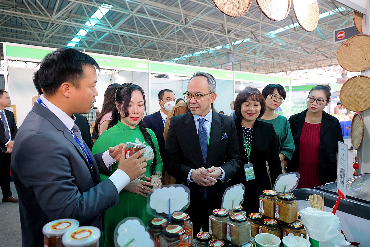 Ông Nikorndej Balankura, Đại sứ Vương quốc Thái Lan tại Việt Nam (giữa) tham quan gian hàng tại Tuần hàng OCOP – Sản vật Việt Nam phát triển và hội nhập.