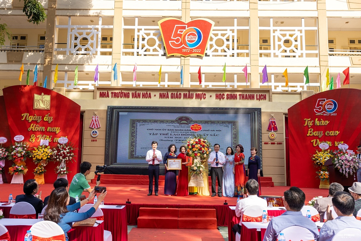 Nhà giáo Đinh Thị Vân Hồng vinh dự lên nhận bằng khen và hoa của đại diện UBND quận Đống Đa. (Ảnh: Nhà trường cung cấp)