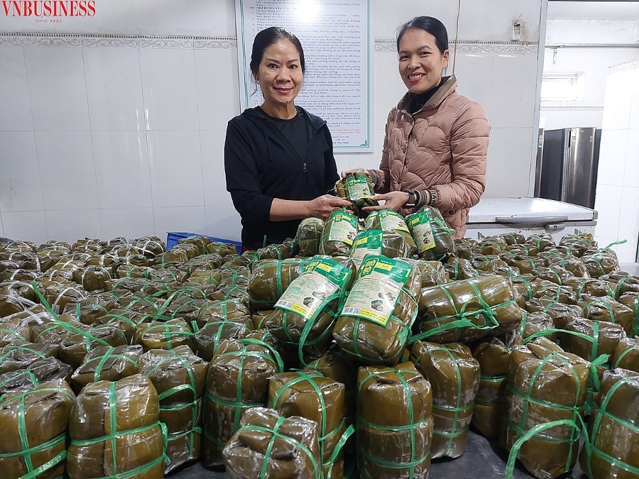 à Tám (người mặc áo đen) giới thiệu một mẻ giò vừa được luộc xong, chuẩn bị dán tem mác.