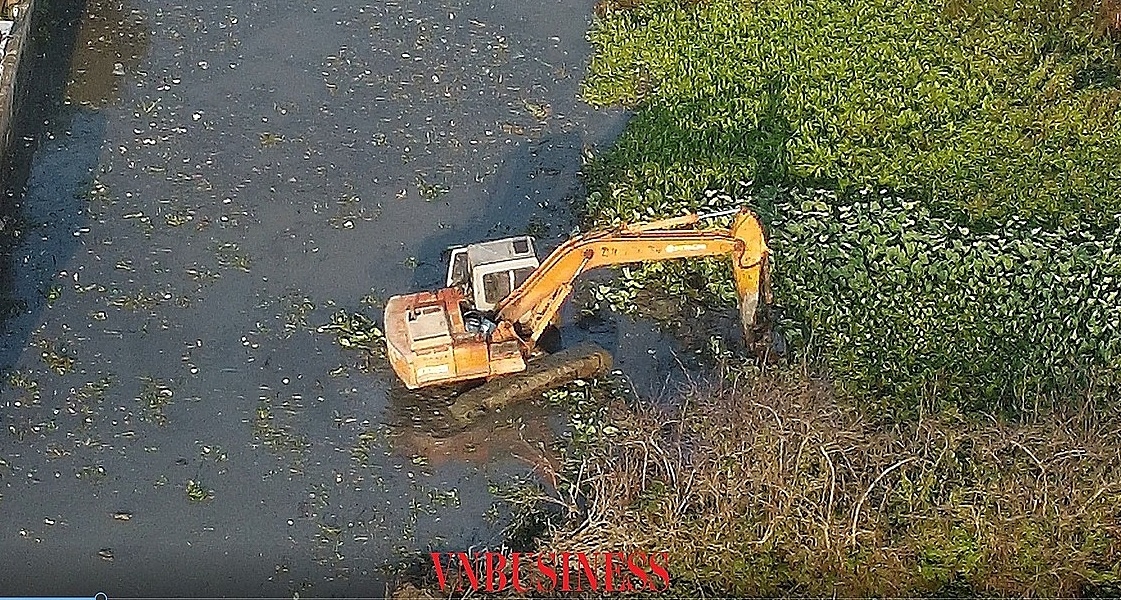Thay vì nạo vét hữu cơ, bùn đổ đi, máy xúc đã vùi cỏ xuống bùn (ảnh cắt từ video).